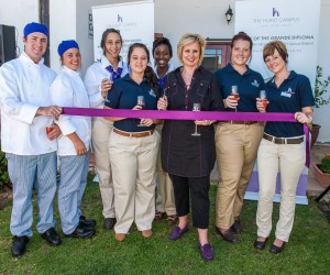 Director Rebecca Hurst prepares to cut the ribbon supported by her students.jpg